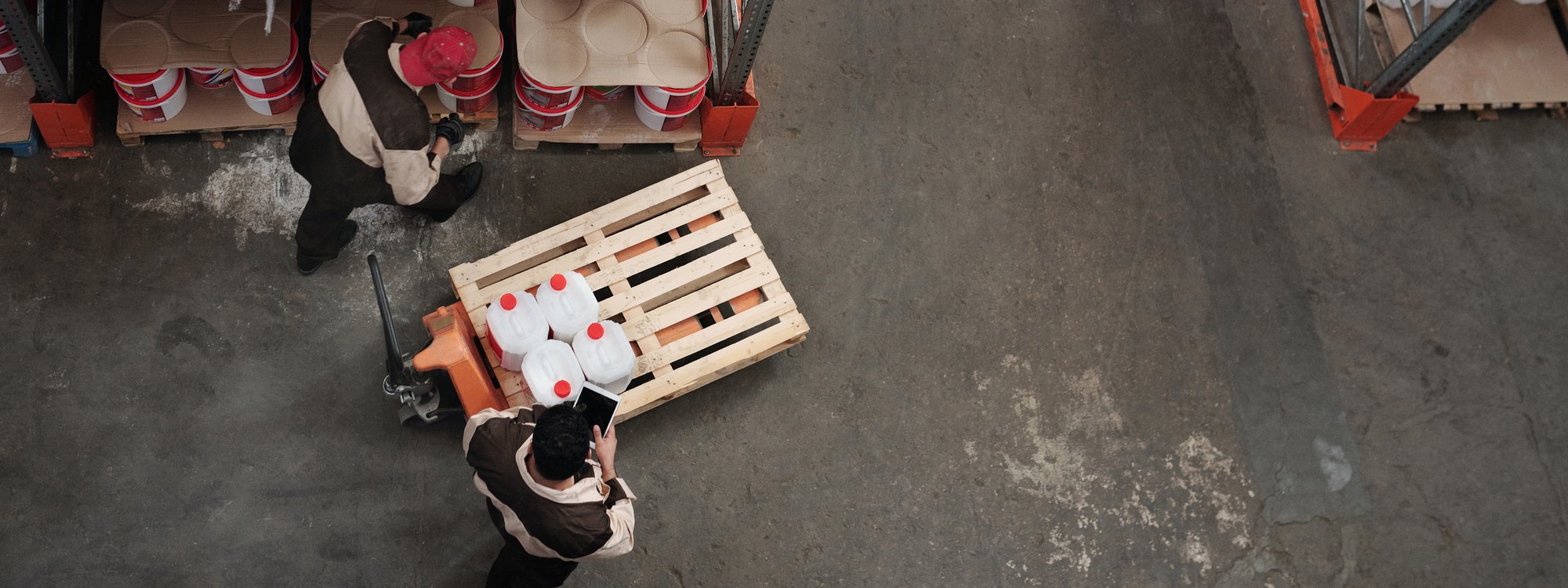Top down view of two warehouse workers managing product inventory