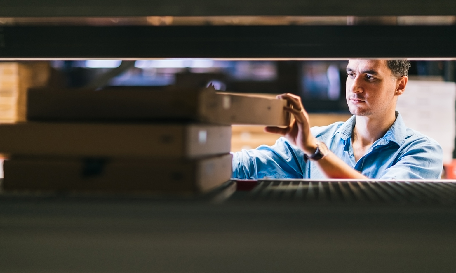 Man picking box from shelf in warehouse, managed by bar code technology